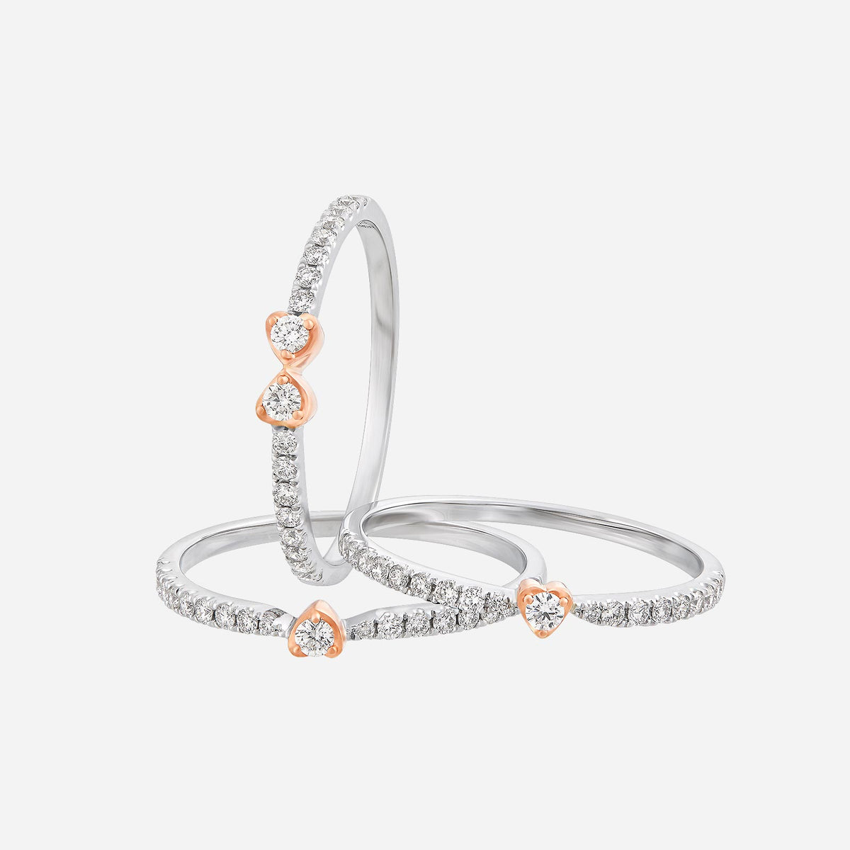 18k white and rose gold stackable diamond rings with floral motifs and heart-shaped accents. elegant and versatile design.