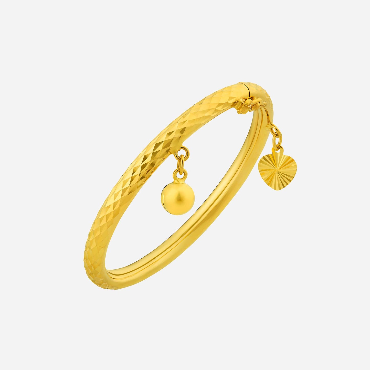 baby bangle in 22k yellow gold with a textured surface, adorned with a dangling bell and heart charm.