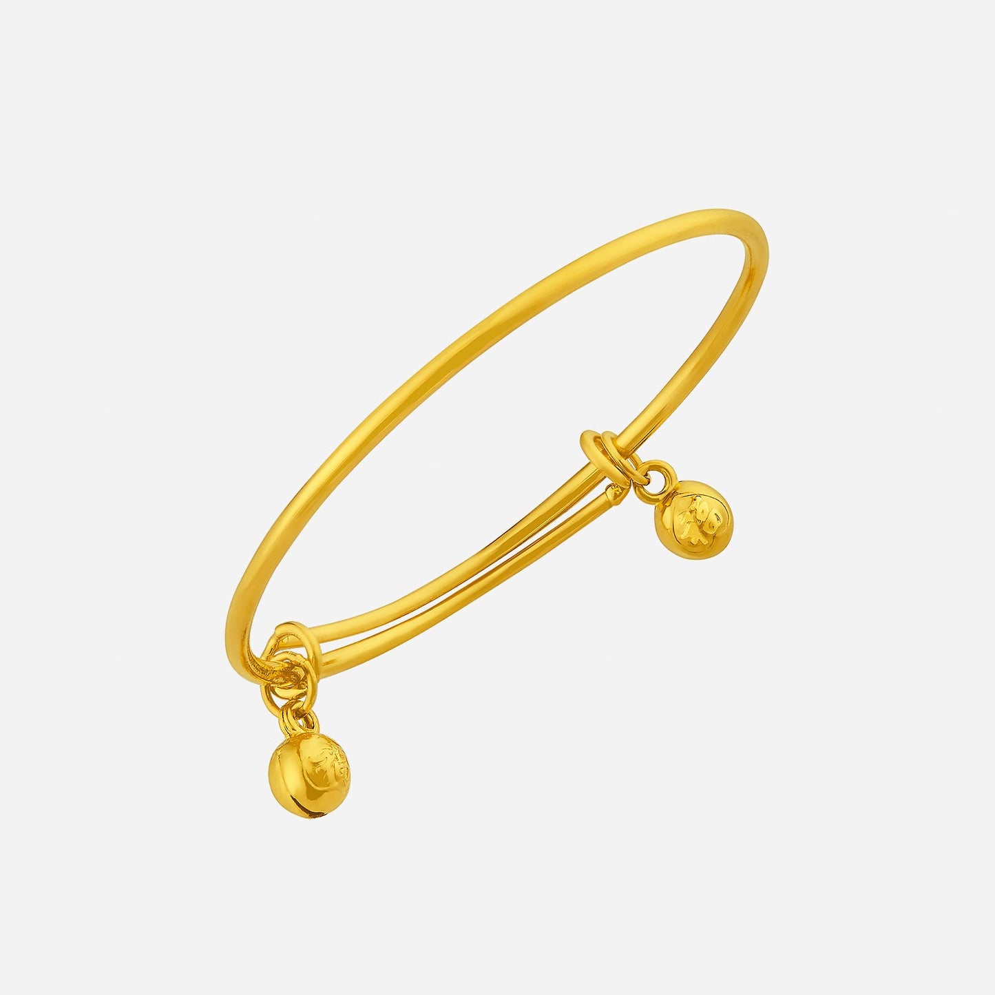24k yellow gold baby bangle with delicate charms, designed to jingle with movement, perfect for a timeless keepsake.