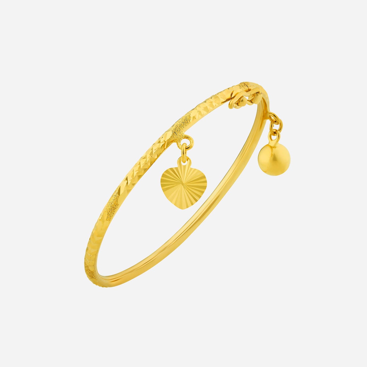 22k yellow gold baby bangle with textured design, featuring a heart charm and a small bell dangling.