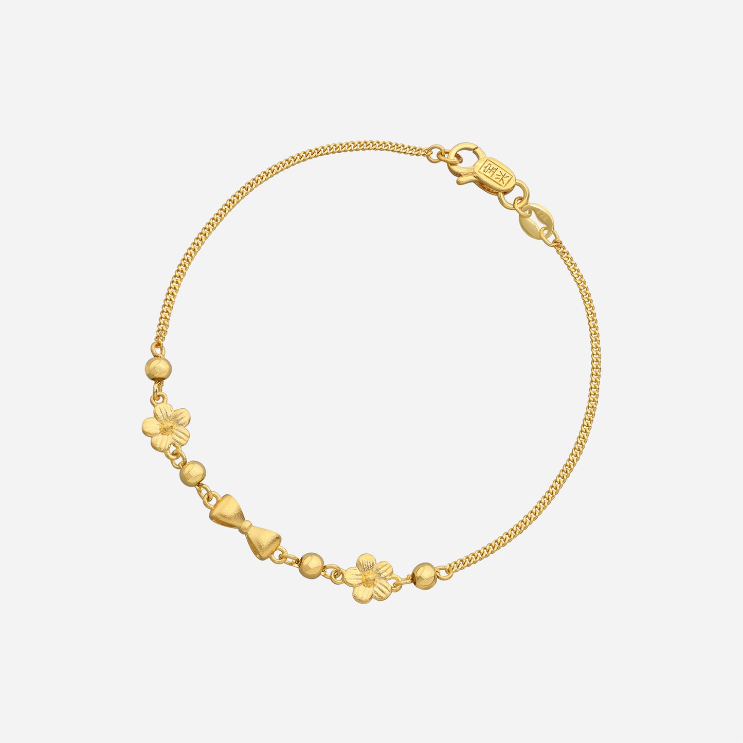 belle bow bracelet in 22k yellow gold featuring a delicate chain, dainty bow, and floral accents.