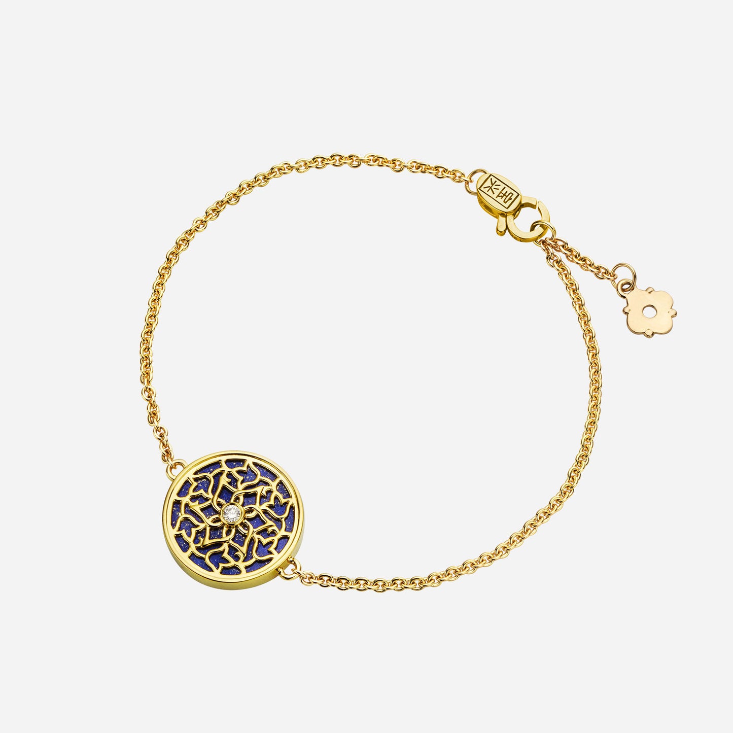 lapis lazuli diamond bracelet in intricate yellow gold floral design on delicate chain, featuring blue gemstone and gold accents.