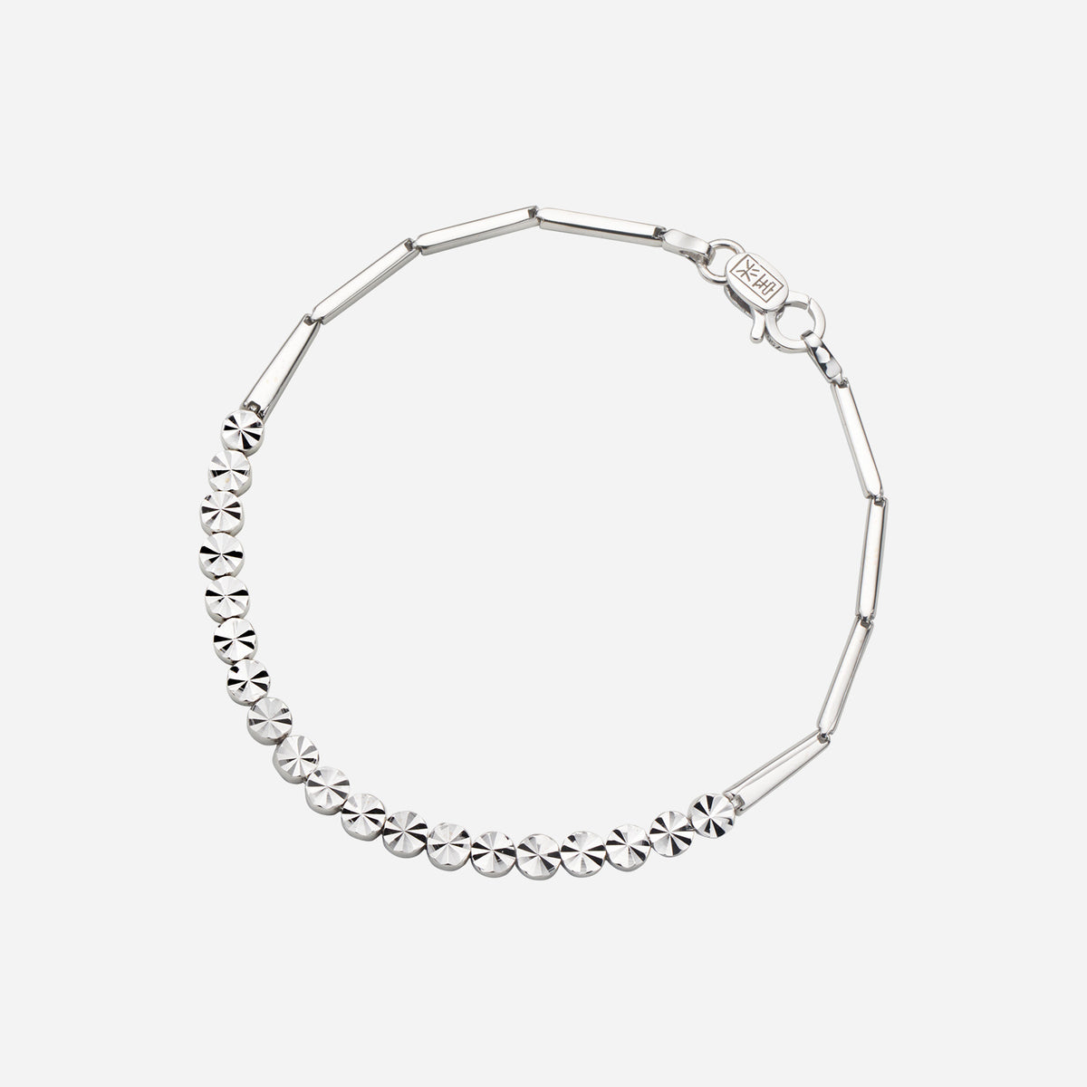 textured bracelet in 18k white gold featuring flat circular motifs and elongated links, showcasing a classic design.