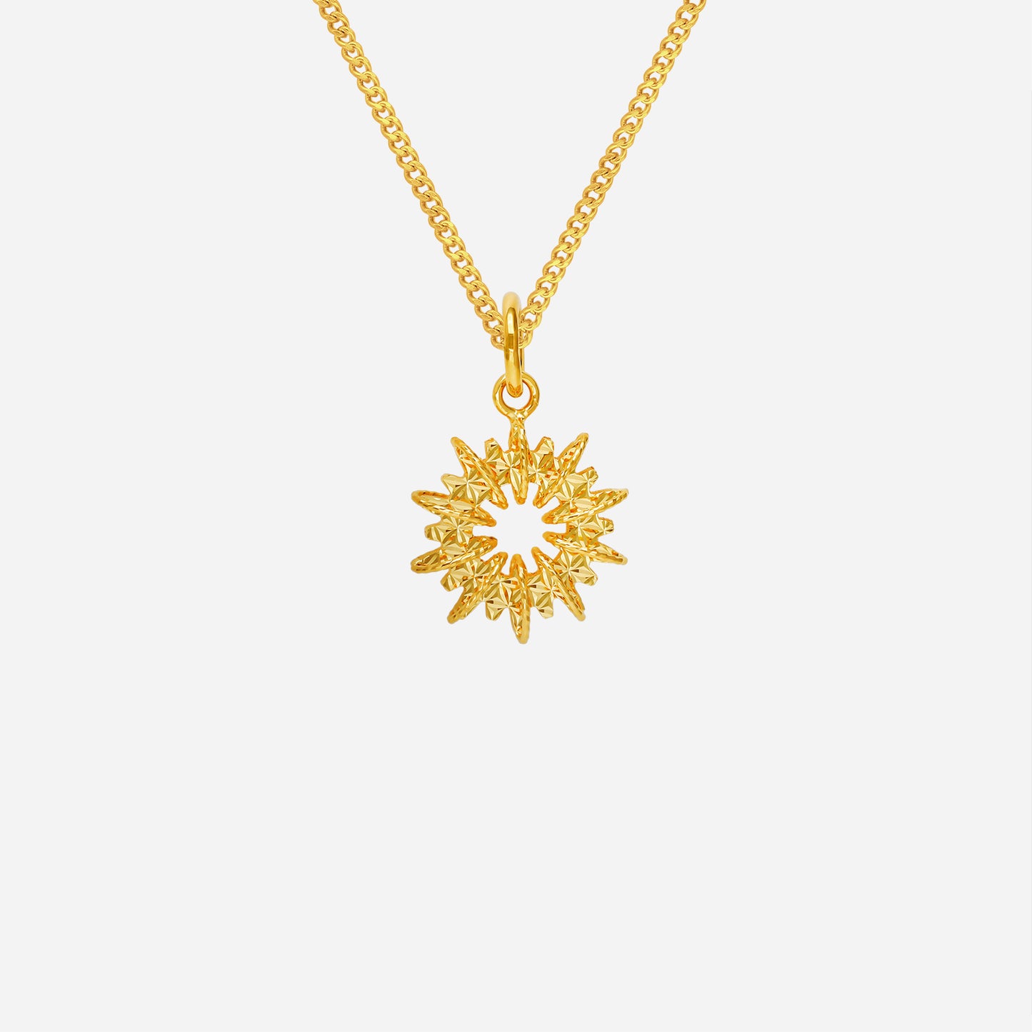sunburst pendant in 22k yellow gold featuring sculpted rays and a radiant halo design. chain not included.