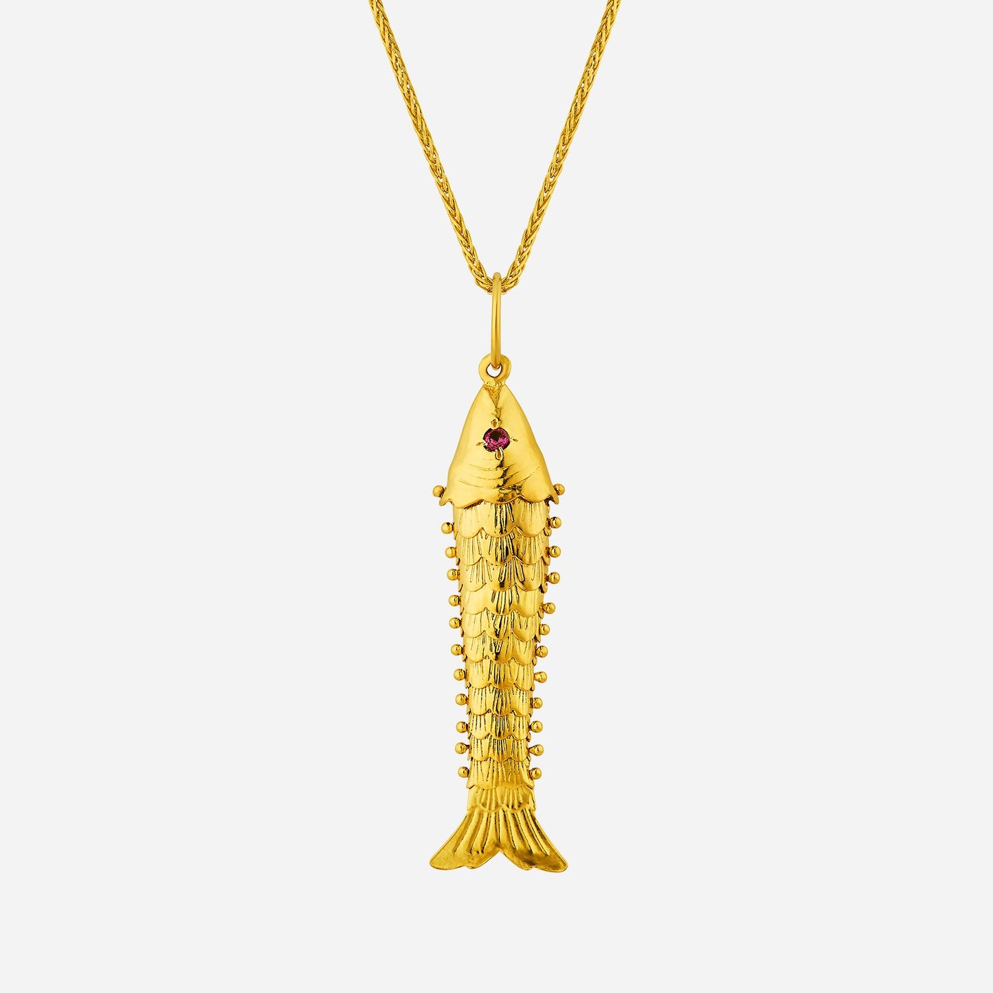 golden fish pendant in 22k yellow gold with intricate design and a small red gemstone accent. chain sold separately.