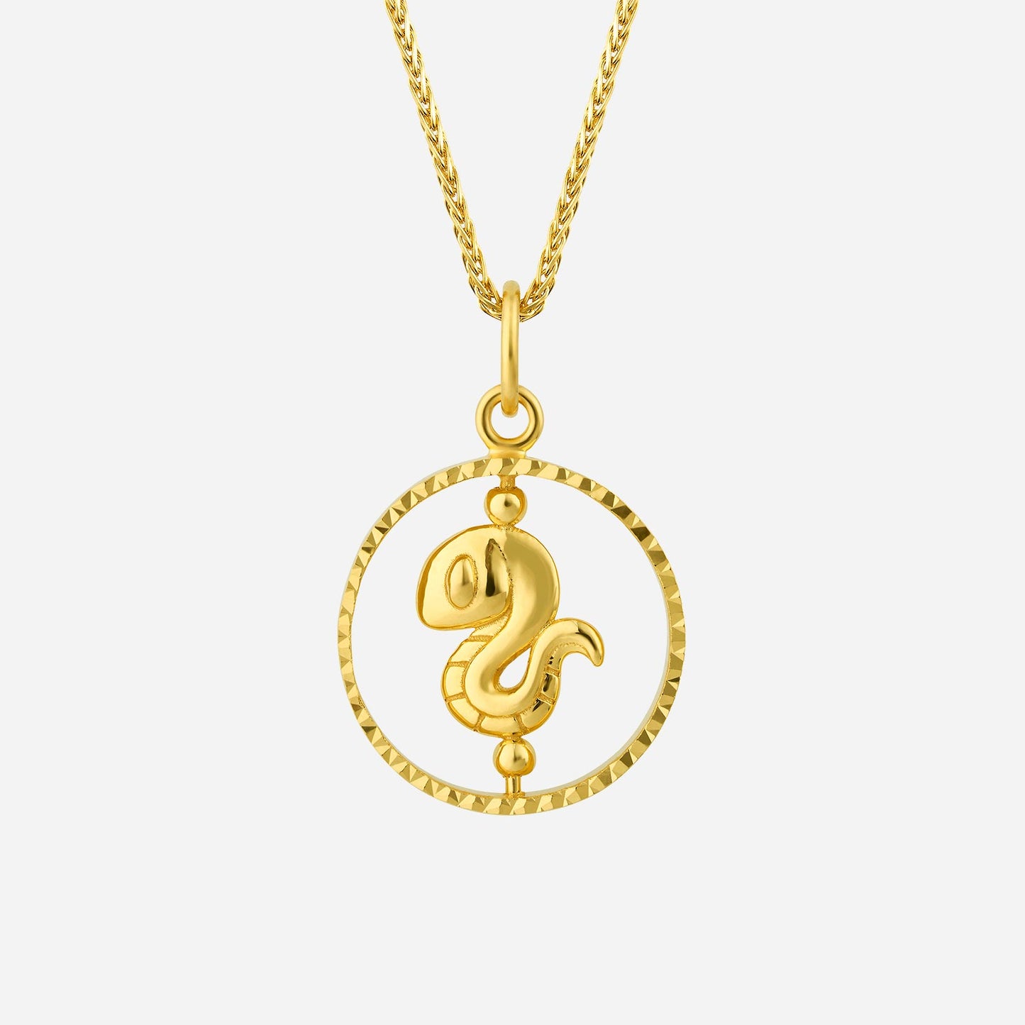 snake pendant in 22k yellow gold with intricate detailing and a circular frame design. elegant and unique jewelry piece.
