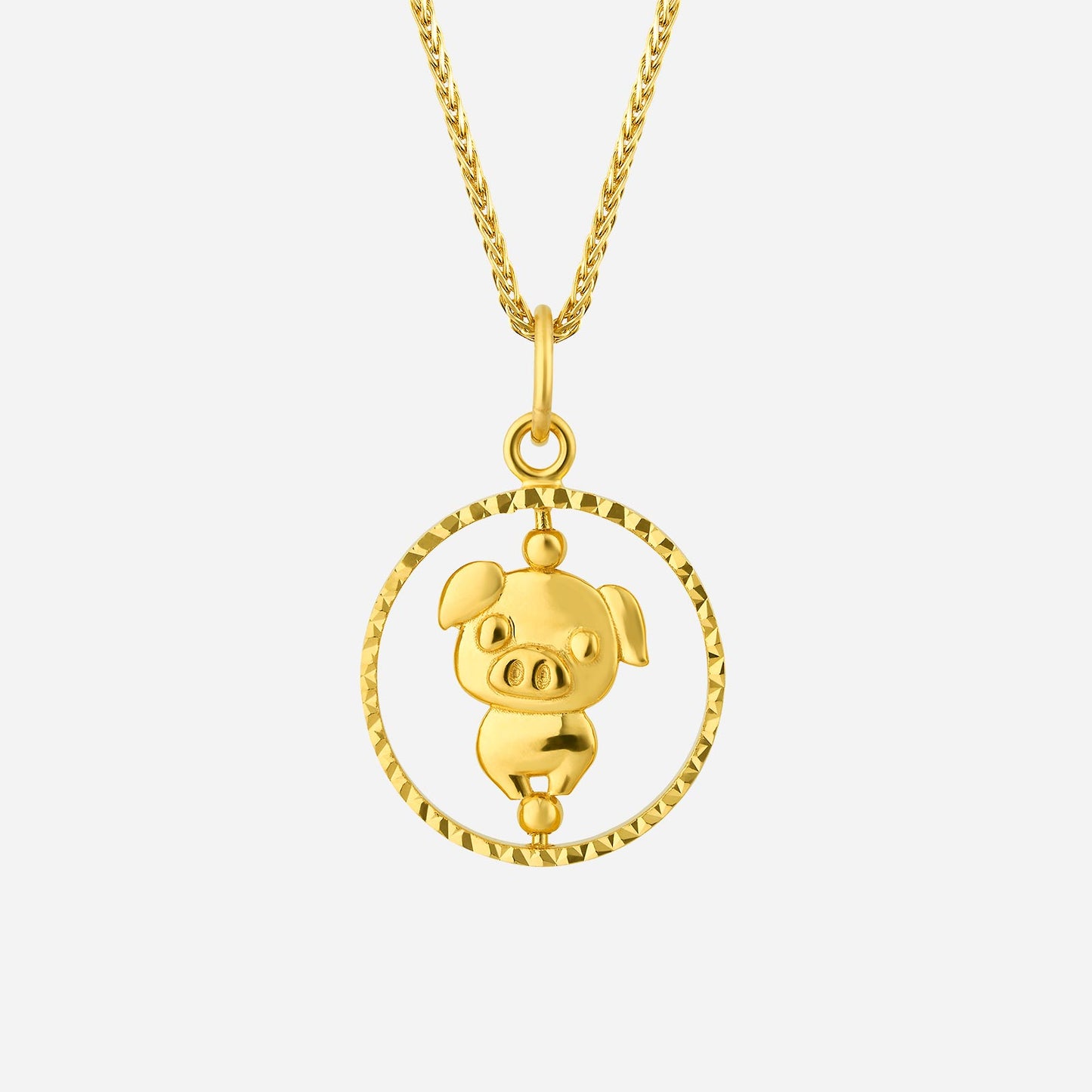 22k yellow gold pig pendant with a playful design, encircled by a textured golden ring. chain not included.
