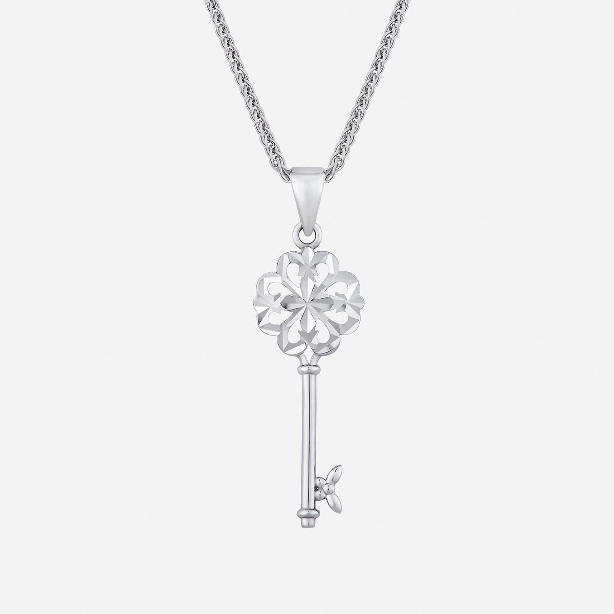 key pendant in 18k white gold with intricate floral design and a sleek key shape, chain sold separately.