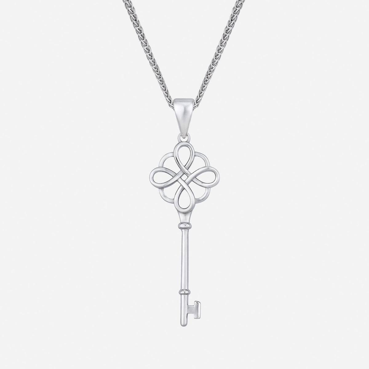 key pendant in 18k white gold with intricate bow design and elegant key shaft. chain not included.
