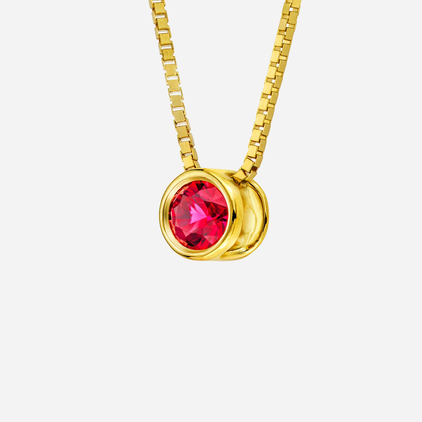 18k yellow gold pendant featuring a round, vibrant red ruby in a sleek, modern setting. chain not included.