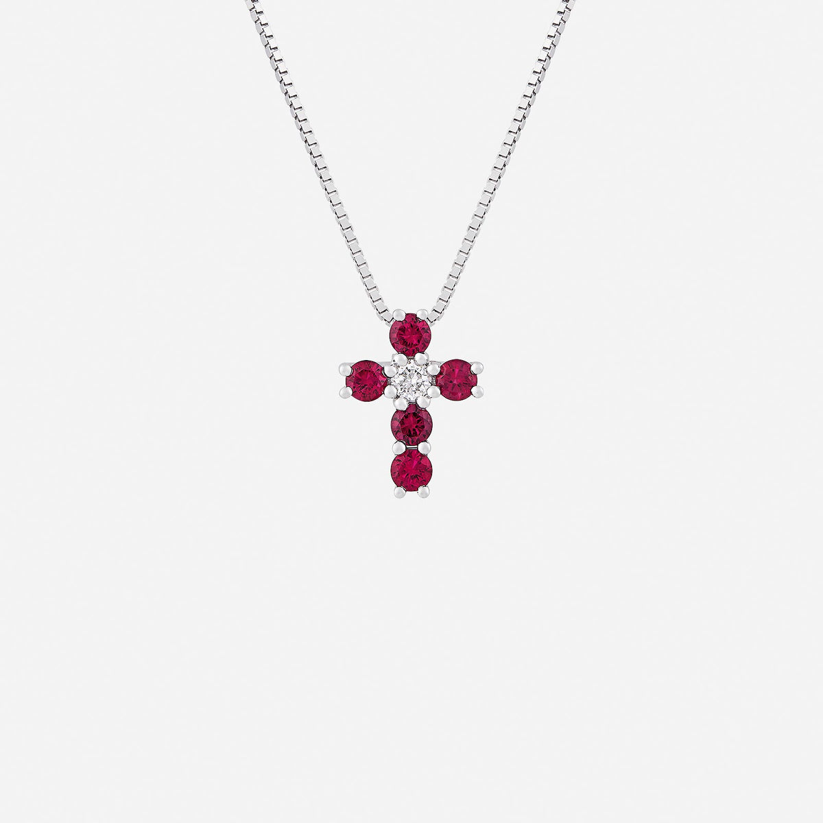 cross pendant in 18k white gold featuring round rubies and brilliant-cut diamonds, symbolizing devotion and grace.