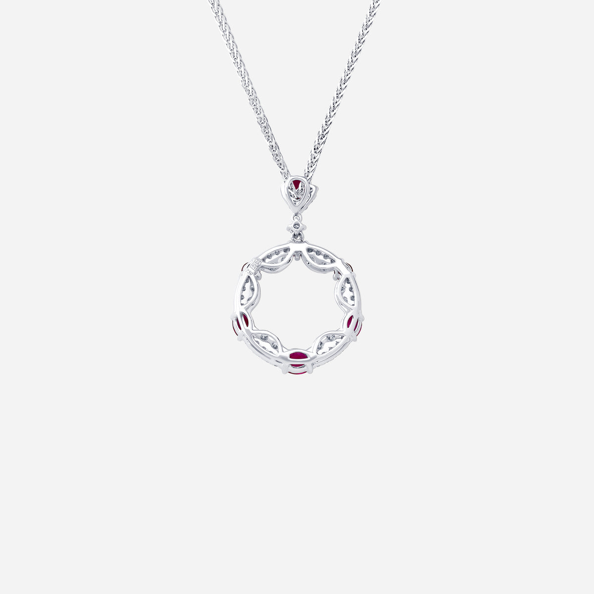 ruby and diamond pendant in 18k white gold with circular openwork design and alternating rubies and diamonds.