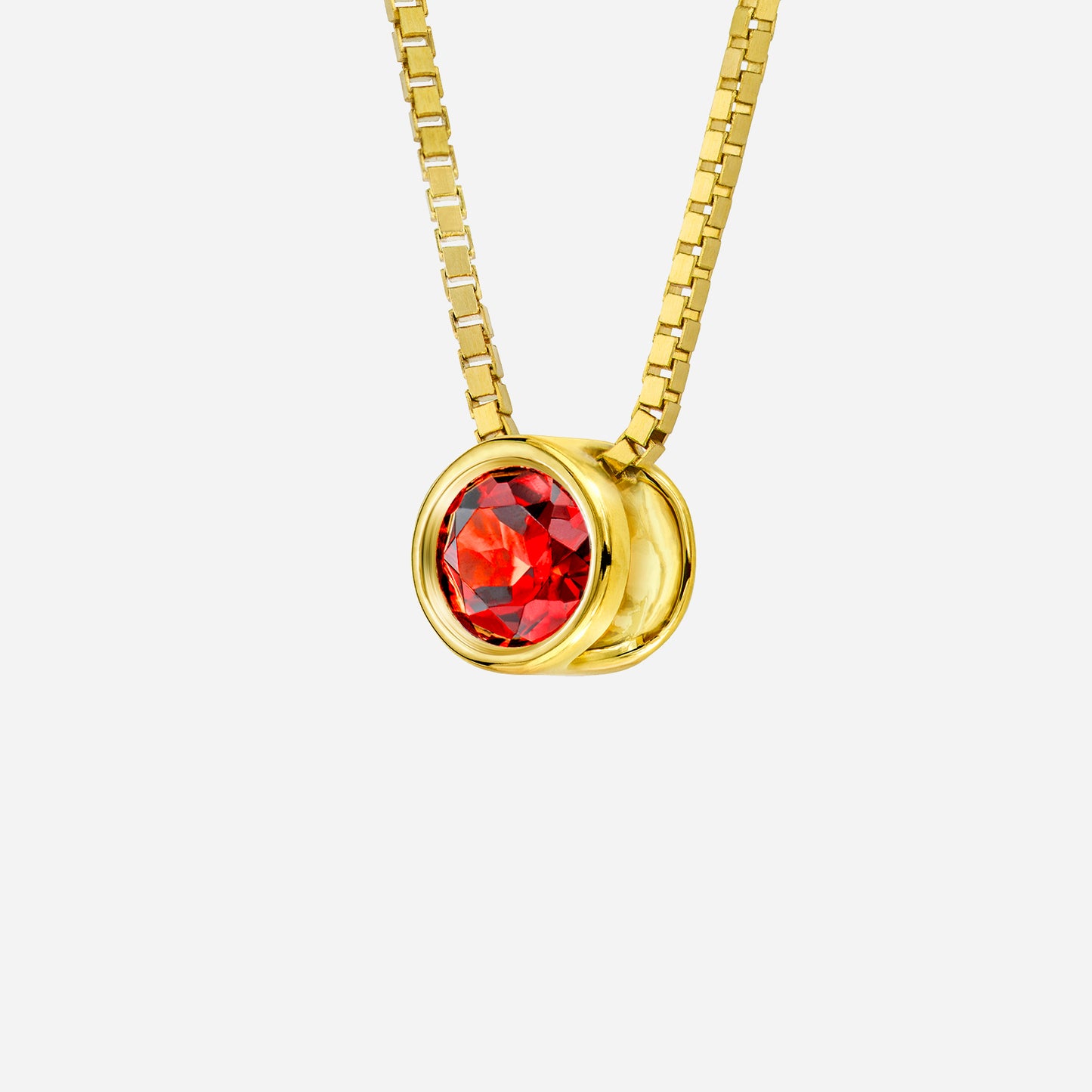 red garnet pendant in 18k yellow gold setting with round cut gemstone, celebrating january's birthstone.