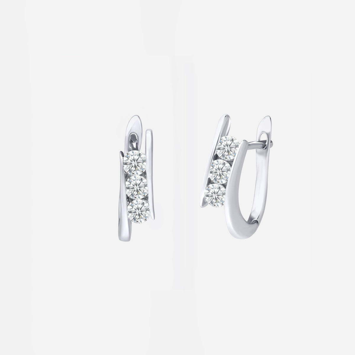 diamond huggie earrings in 18k white gold with three sparkling diamonds in a sleek curved design.