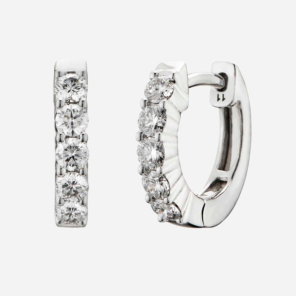 petite 18k white gold huggie earrings featuring a row of sparkling diamonds along the rim.