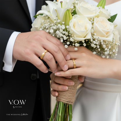 Yellow gold Timeless Love Bands showcasing a refined design, symbolizing commitment, held by a couple.