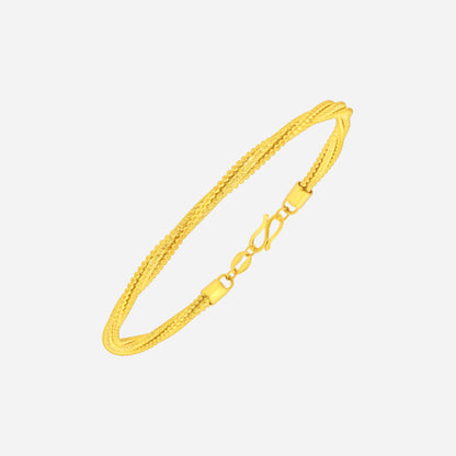 Twisted bangle in 24K yellow gold featuring rope-like detailing and refined texture for timeless elegance.