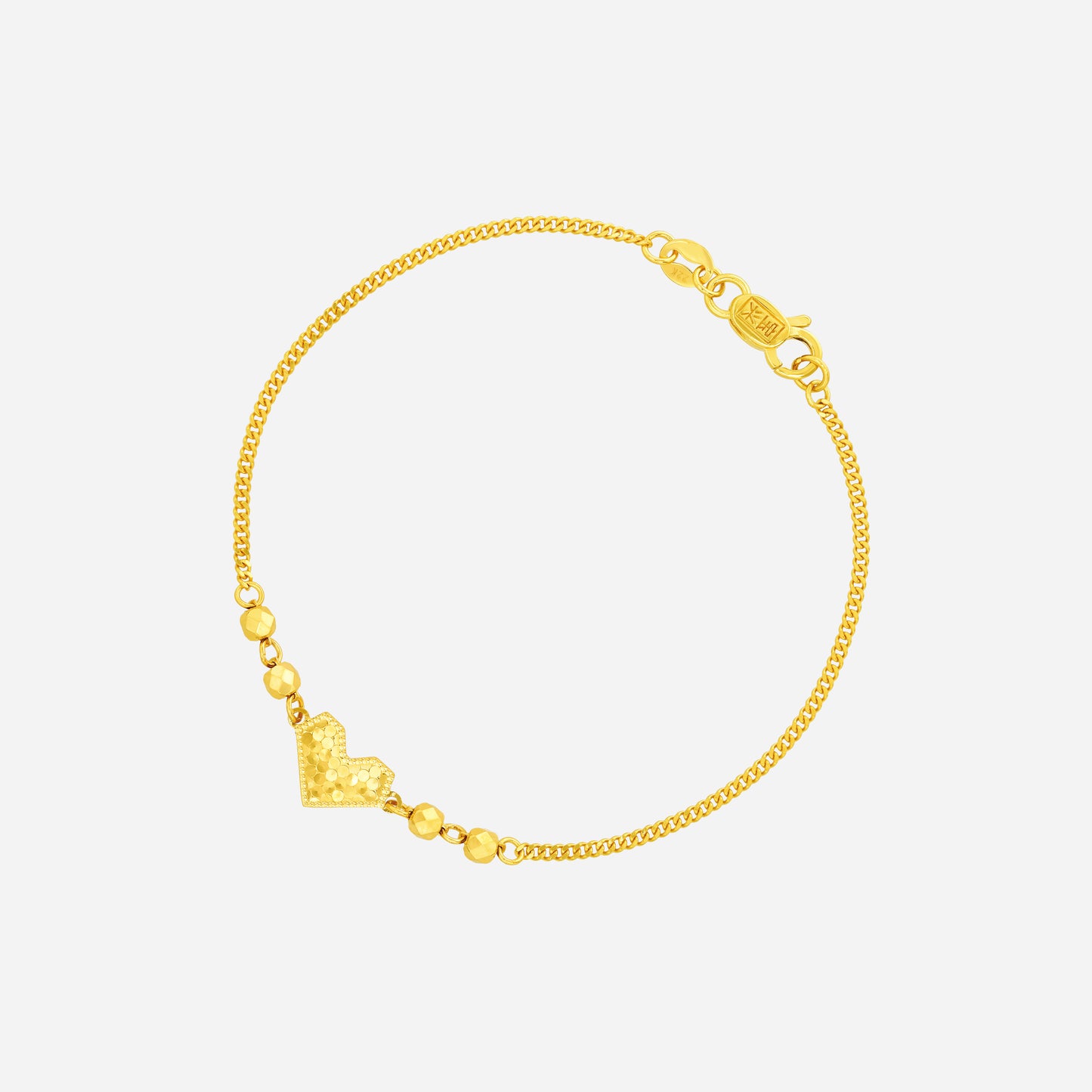 radiant heart bracelet in 22k yellow gold with textured heart centerpiece and gold beads on a fine chain.