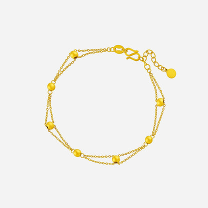 24K yellow gold beaded bracelet with delicate beads on a triple-strand chain, perfect for any occasion.