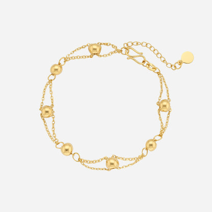 24K yellow gold beaded bracelet on a triple-strand chain, featuring delicate gold beads and a secure clasp.