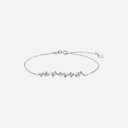Baguette diamond and round diamond bracelet in 18K white gold with a wave design. Elegant and versatile for layering.
