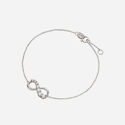 Love Journey infinity bracelet in 18K white gold with brilliant cut diamonds in ascending sizes. Elegant design detail.