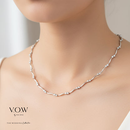 Caressing Waves diamond necklace in 18K white gold with shimmering diamonds set in a fluid, wavy design.