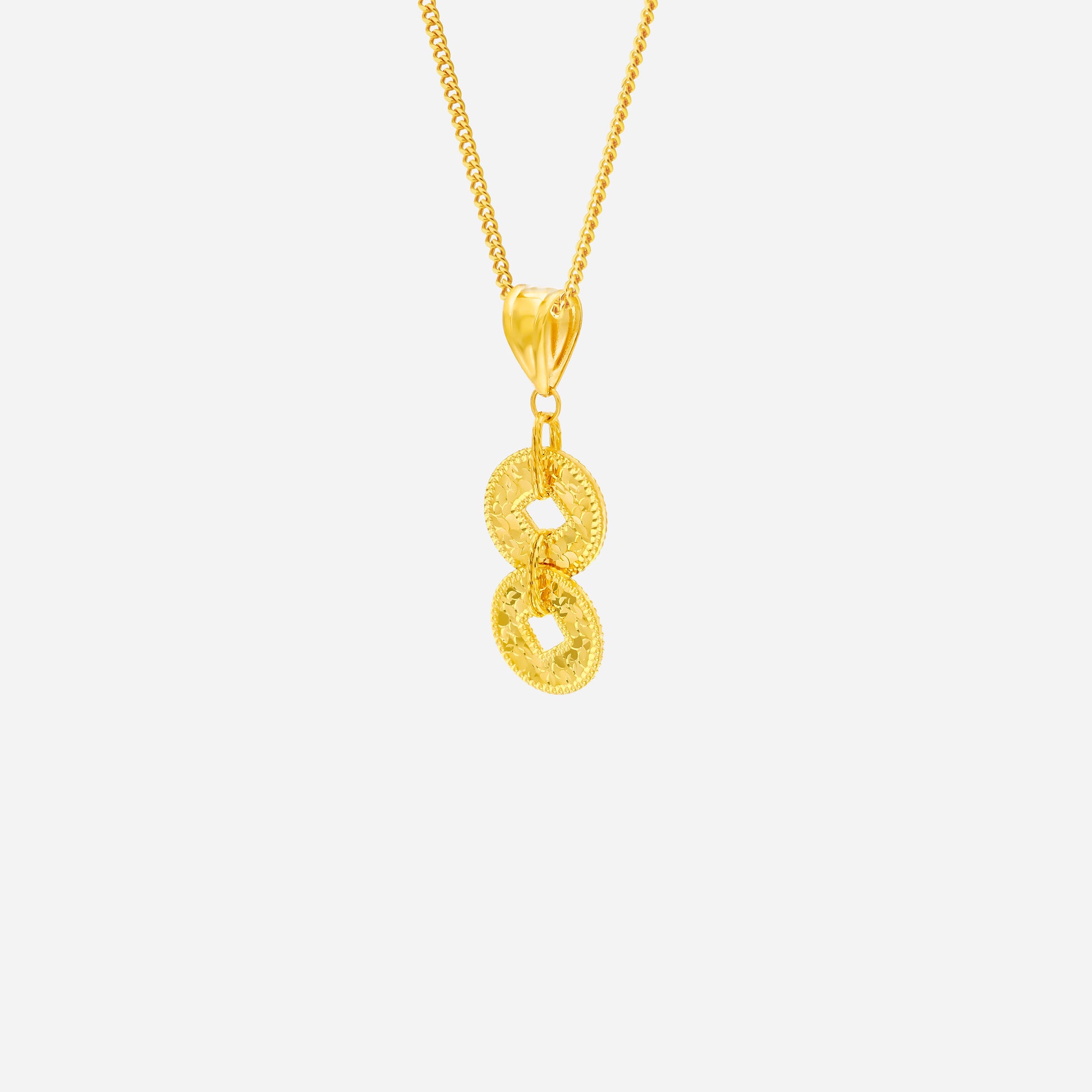Yellow gold coin pendant with intricate detailing, featuring two interlinked coins on a delicate chain.