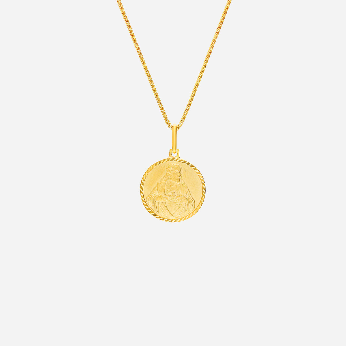 sacred heart pendant in 22k yellow gold with intricate design, featuring a textured round medallion. chain not included.