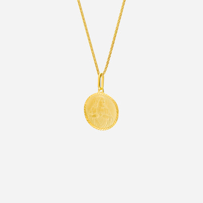 Sacred Heart pendant in 22K yellow gold with intricate engraving, hanging from a twisted gold chain.