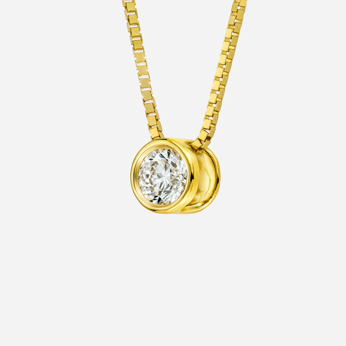 diamond pendant in 18k yellow gold with a circular design, featuring a brilliant april birthstone diamond.