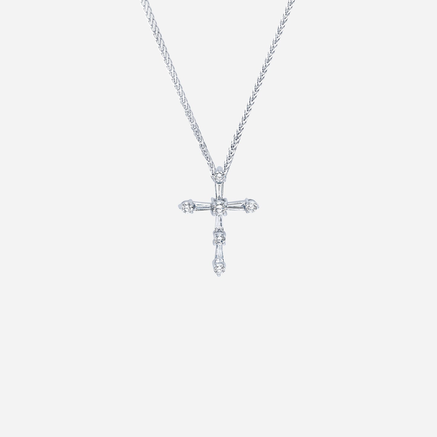 cross diamond pendant in 18k white gold featuring tapered and round diamonds in a modern design. chain not included.