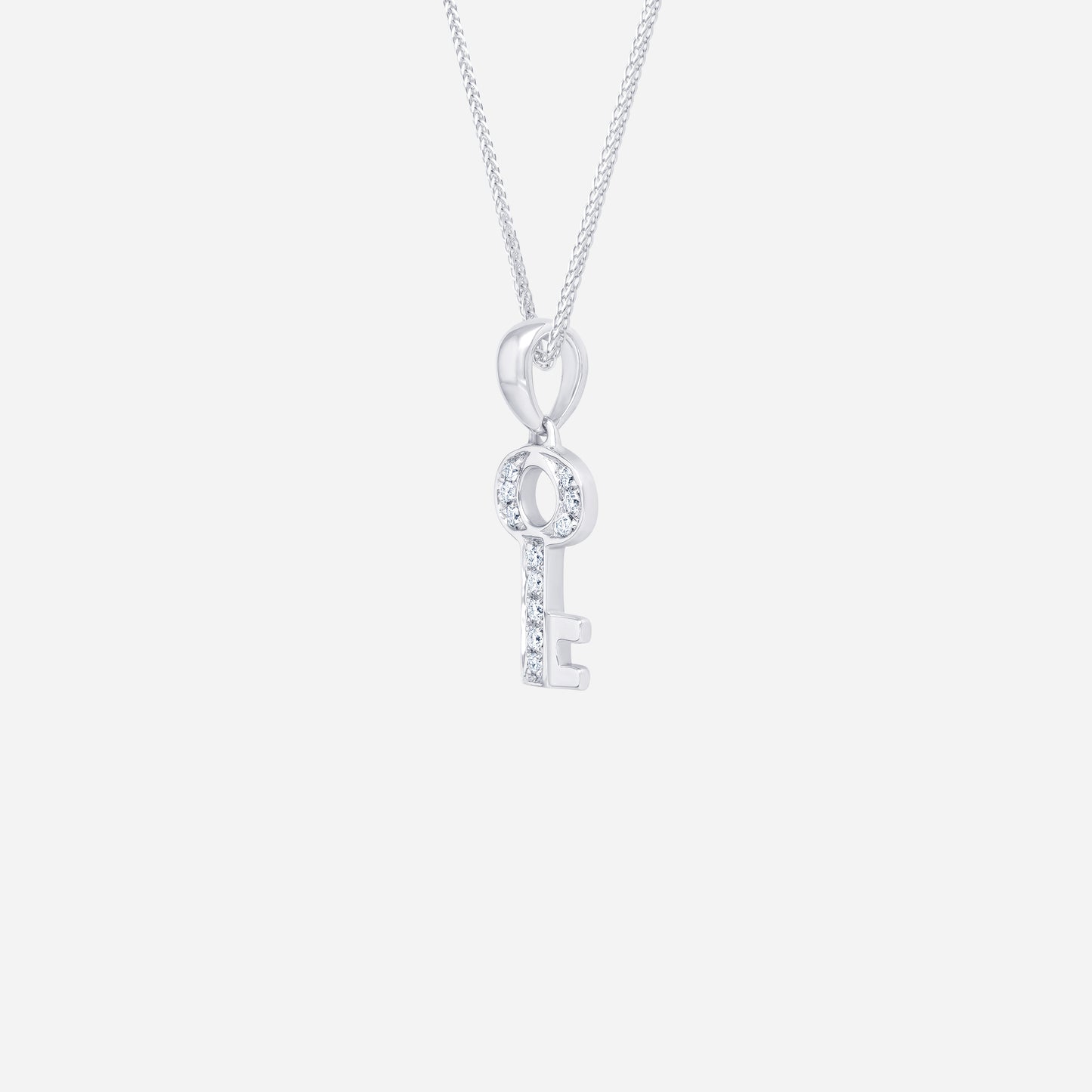 key pendant in 18k white gold featuring a diamond-studded design, symbolizing dreams and memories.