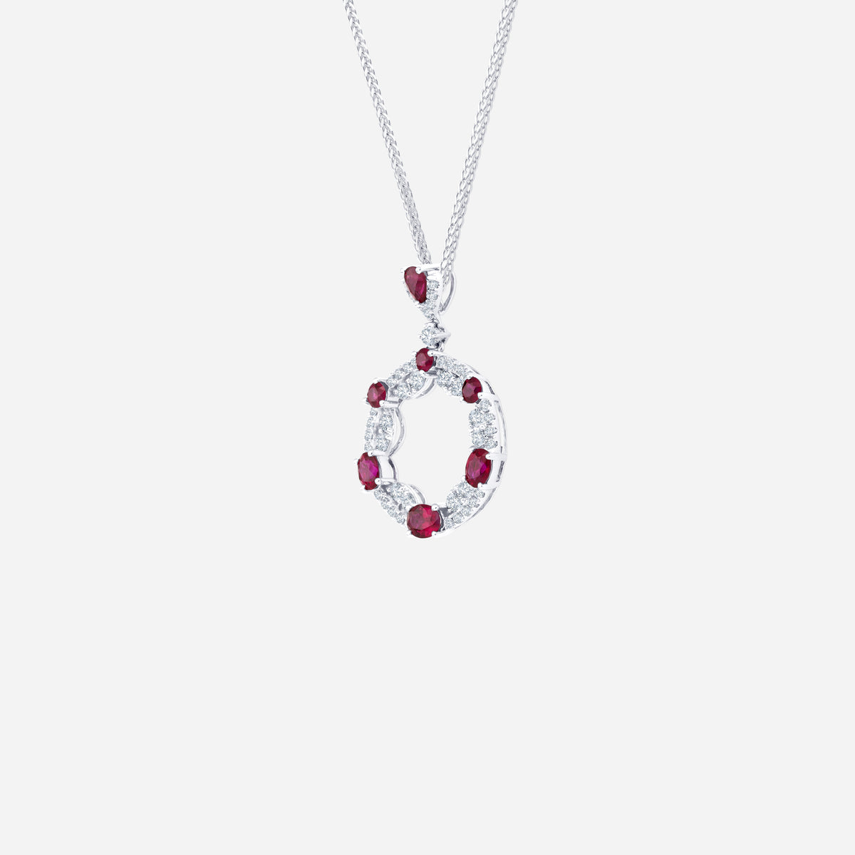 ruby and diamond pendant in 18k white gold with circular openwork design, featuring alternating rubies and diamonds.