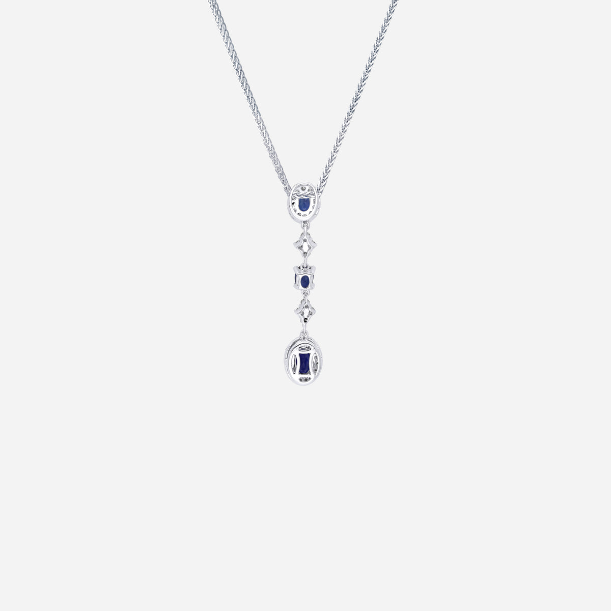 Blue sapphire pendant with diamond accents in 18K white gold, featuring a cascading design and oval gemstones.