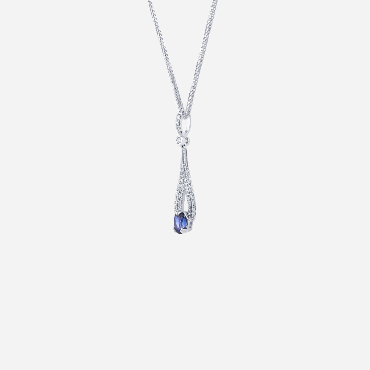 Blue sapphire pendant in 18K white gold with diamond pavé detailing in an elegant teardrop design.
