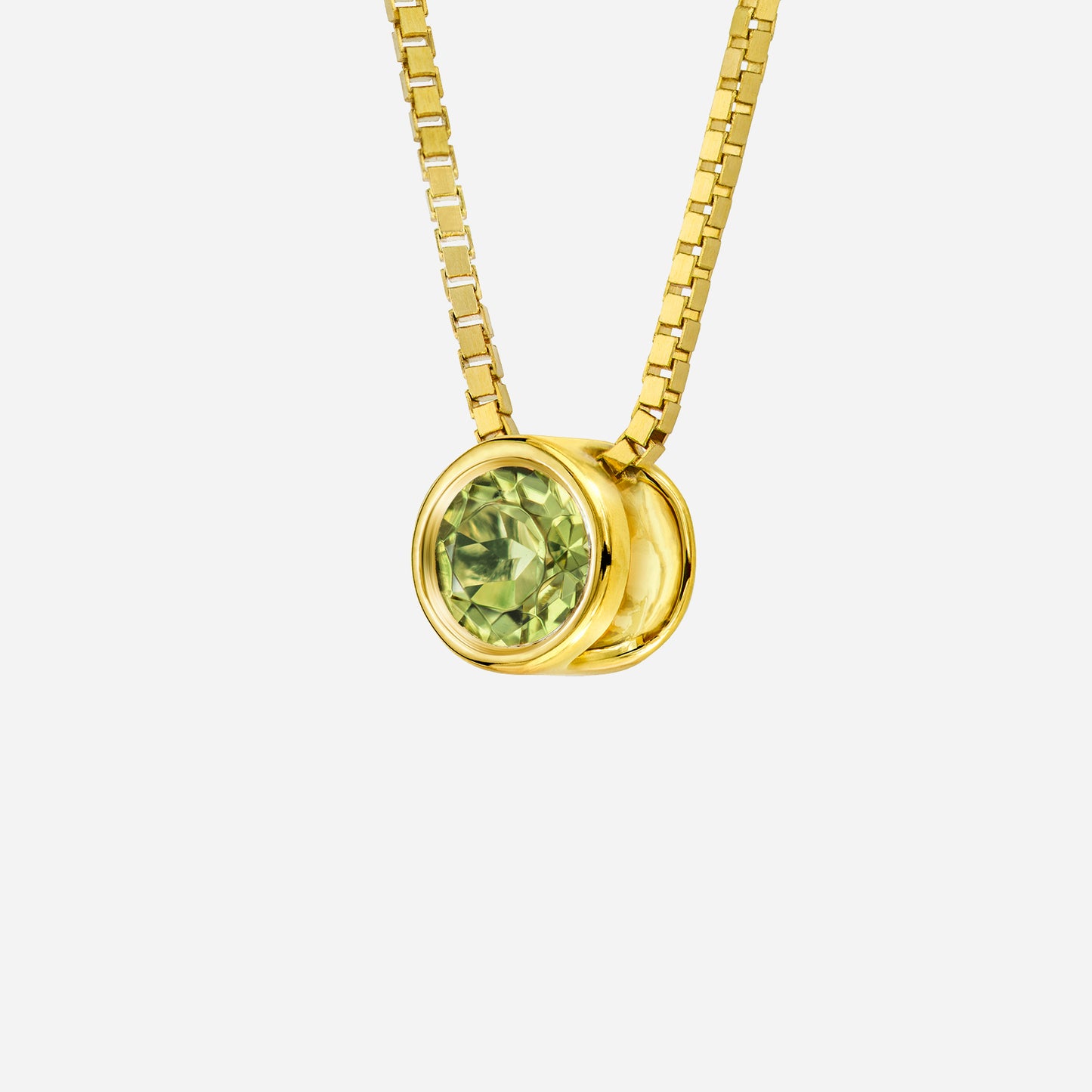 peridot pendant in 18k yellow gold with a round, pale yellow-green gemstone and sleek setting. chain not included.