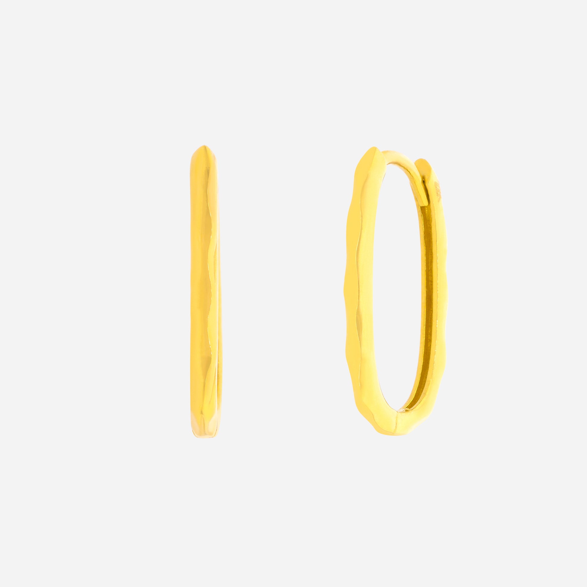 Oval curved huggie earrings in 22K yellow gold with a minimal fluid design, showcasing a softened hoop shape.