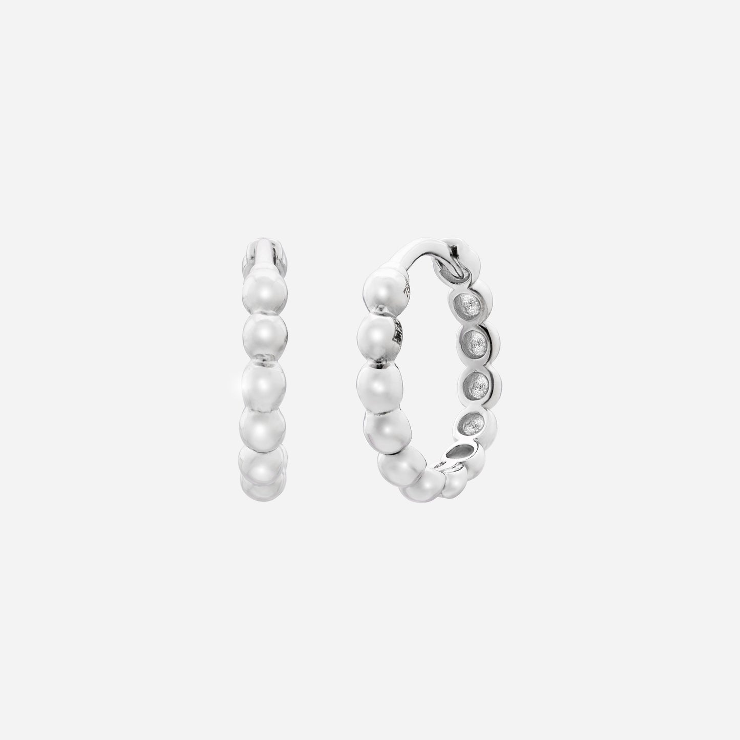 huggie earrings in 18k white gold with polished bead-like details and a softly rounded silhouette.