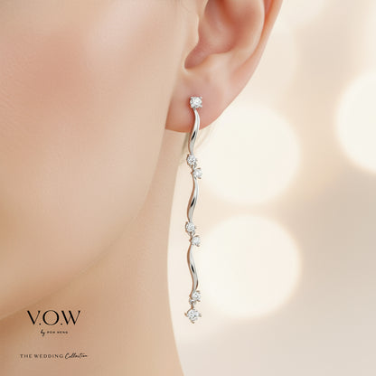 Caressing Waves diamond earrings in 18K white gold with curved strands and sparkling diamonds catching the light.