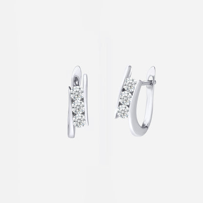 Diamond huggie earrings in 18K white gold featuring three sparkling diamonds on a sleek, curved design.