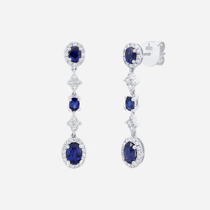 Blue sapphire and diamond earrings in 18K white gold with cascading design and delicate diamond accents.
